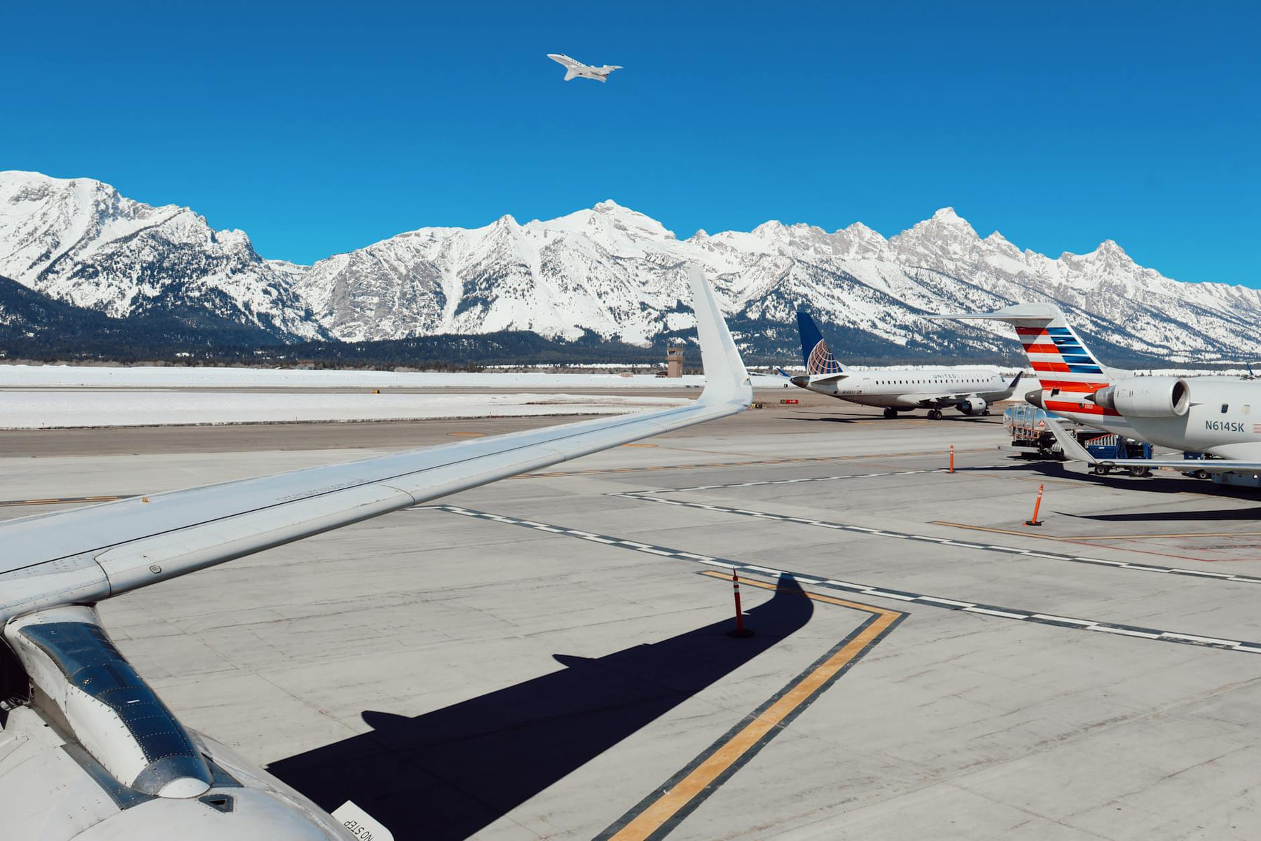 Airplanes at Jackson Airport with scenic snowy peaks in the background. on Miles and Memories