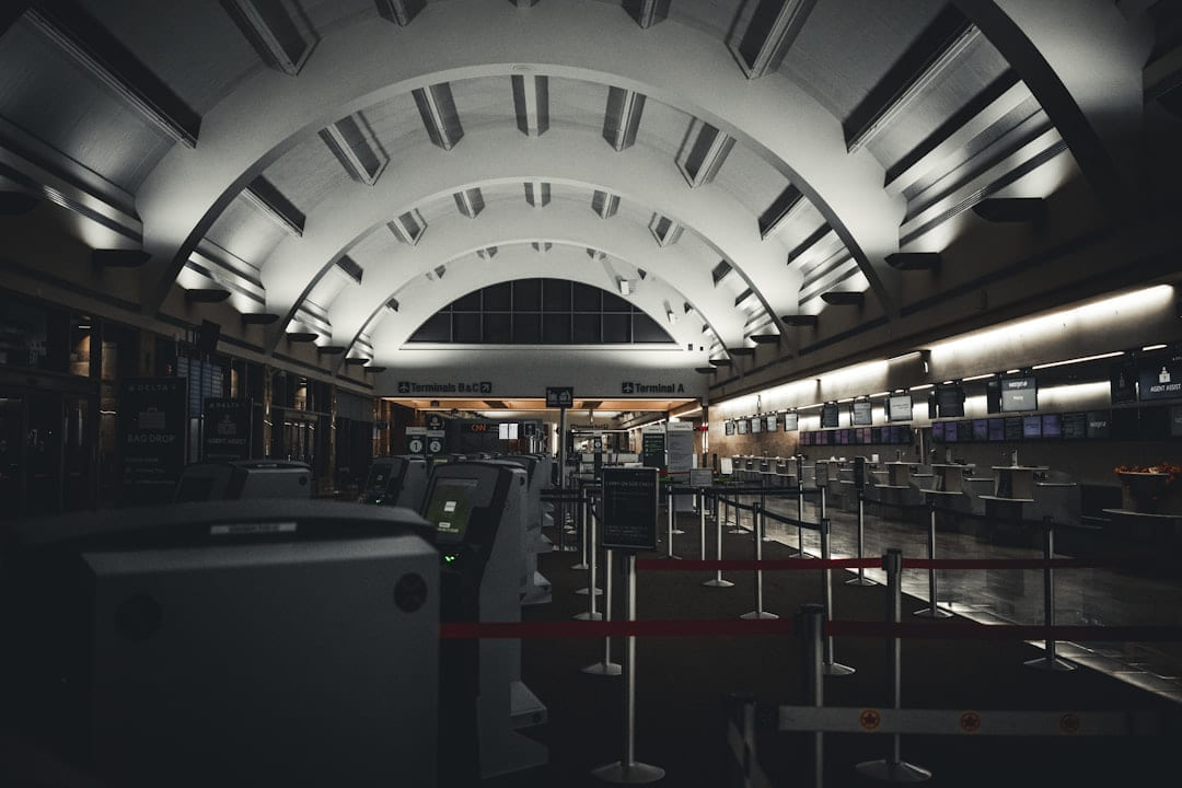 Empty airport terminal with rows of check-in counters. on Miles and Memories