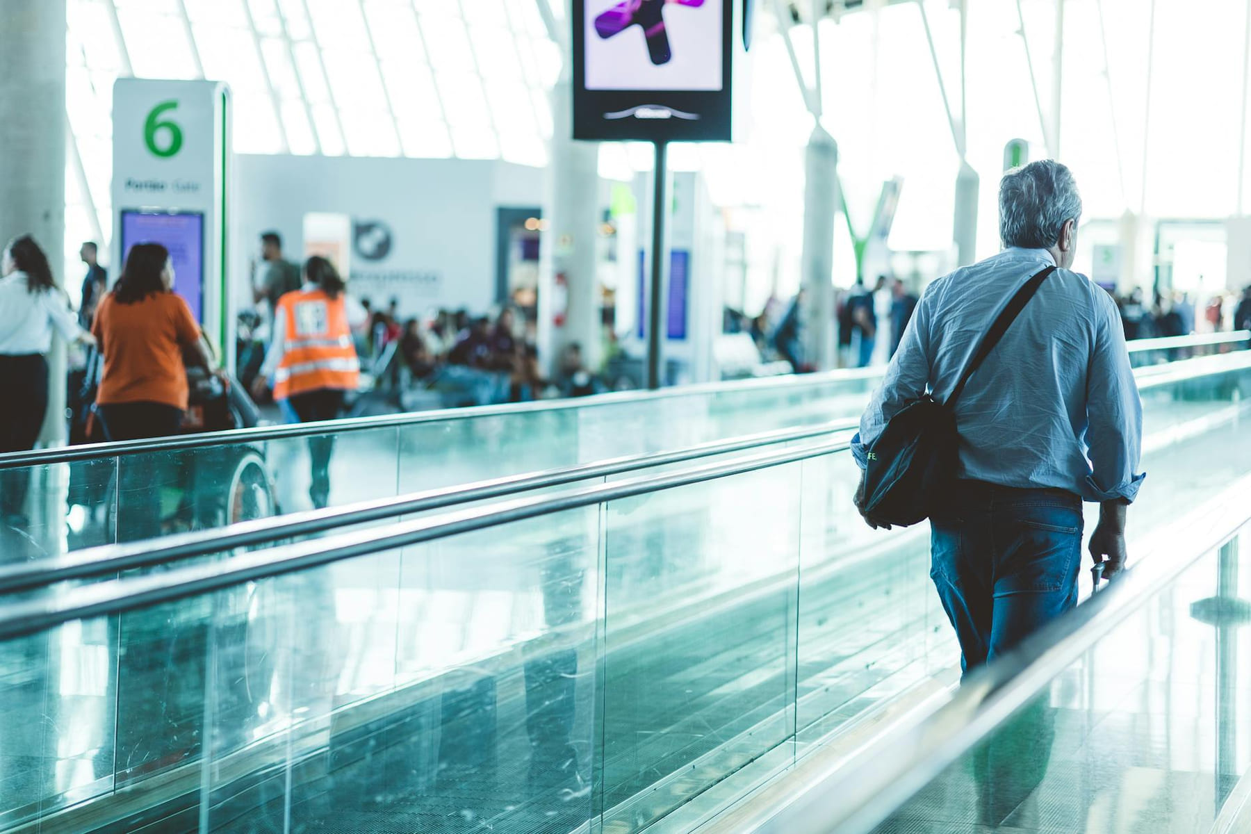 A bustling airport scene with travelers on a moving walkway in a modern terminal. on Miles and Memories
