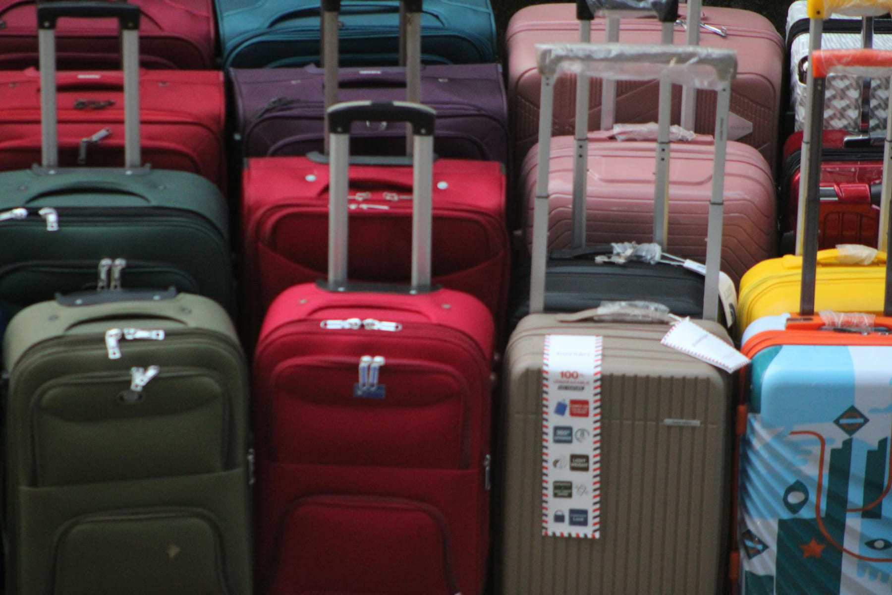 A vibrant collection of various suitcases stacked in preparation for travel. on Miles and Memories