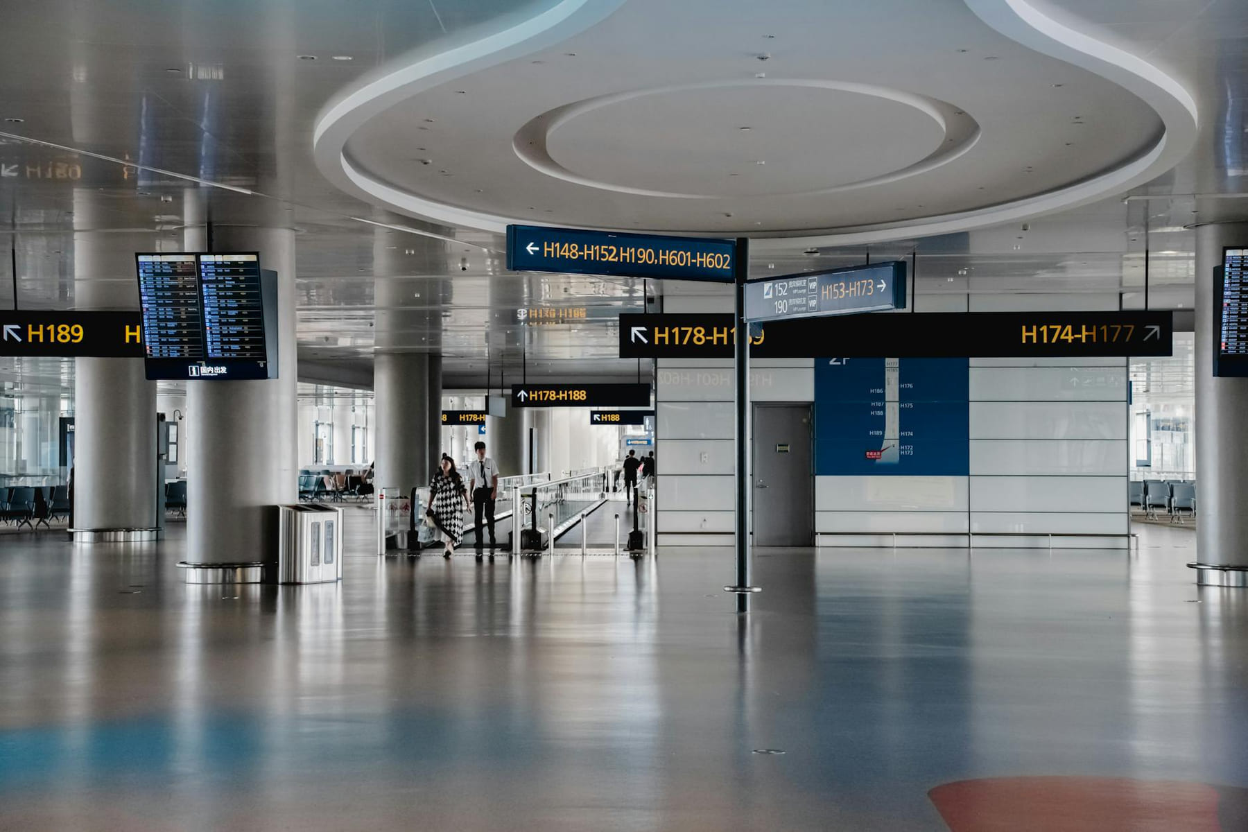 Spacious interior view of a modern airport terminal in Shanghai with signage and travelers. on Miles and Memories