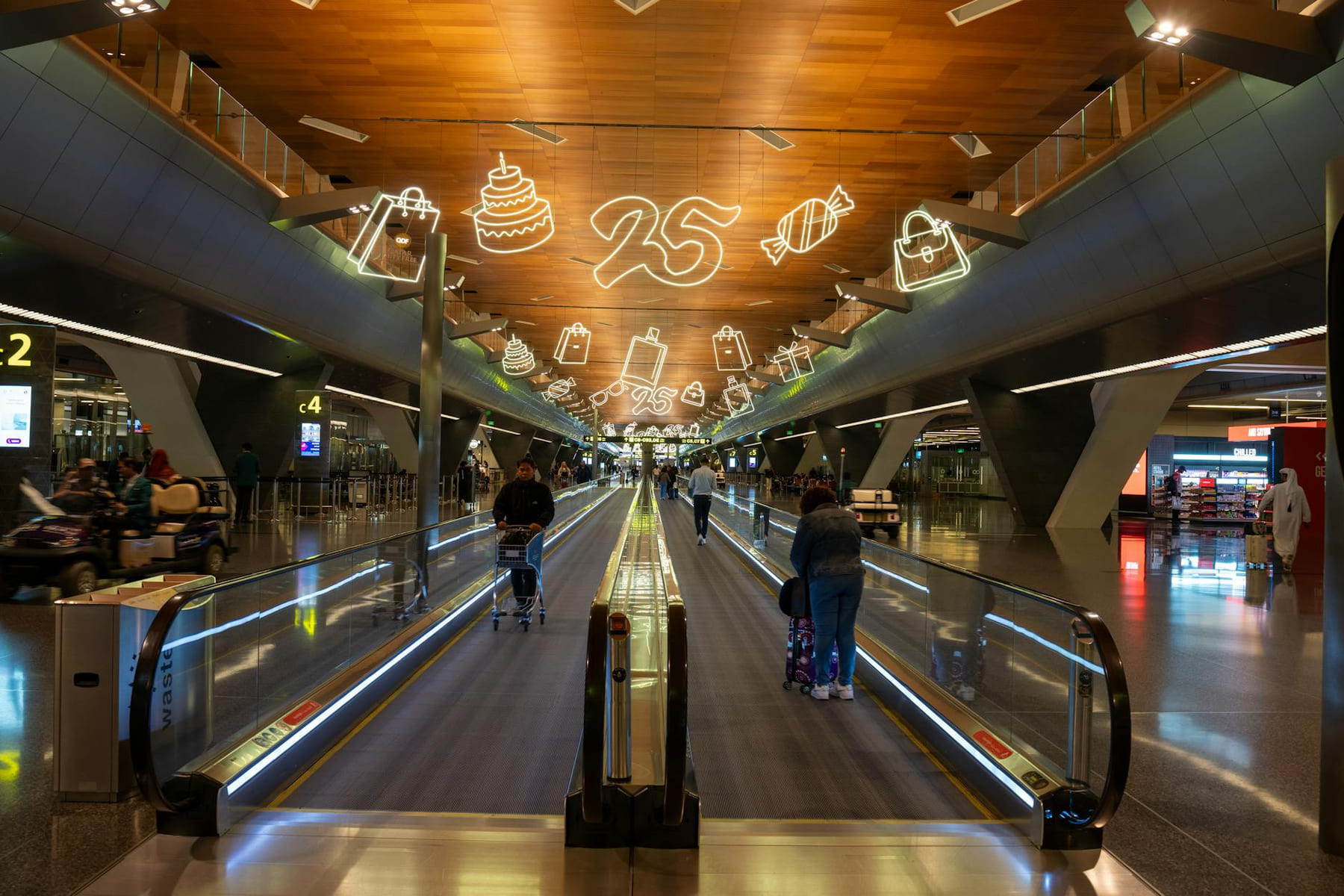 Dynamic scene of travelers at Doha Hamad International Airport with festive ceiling decor. on Miles and Memories