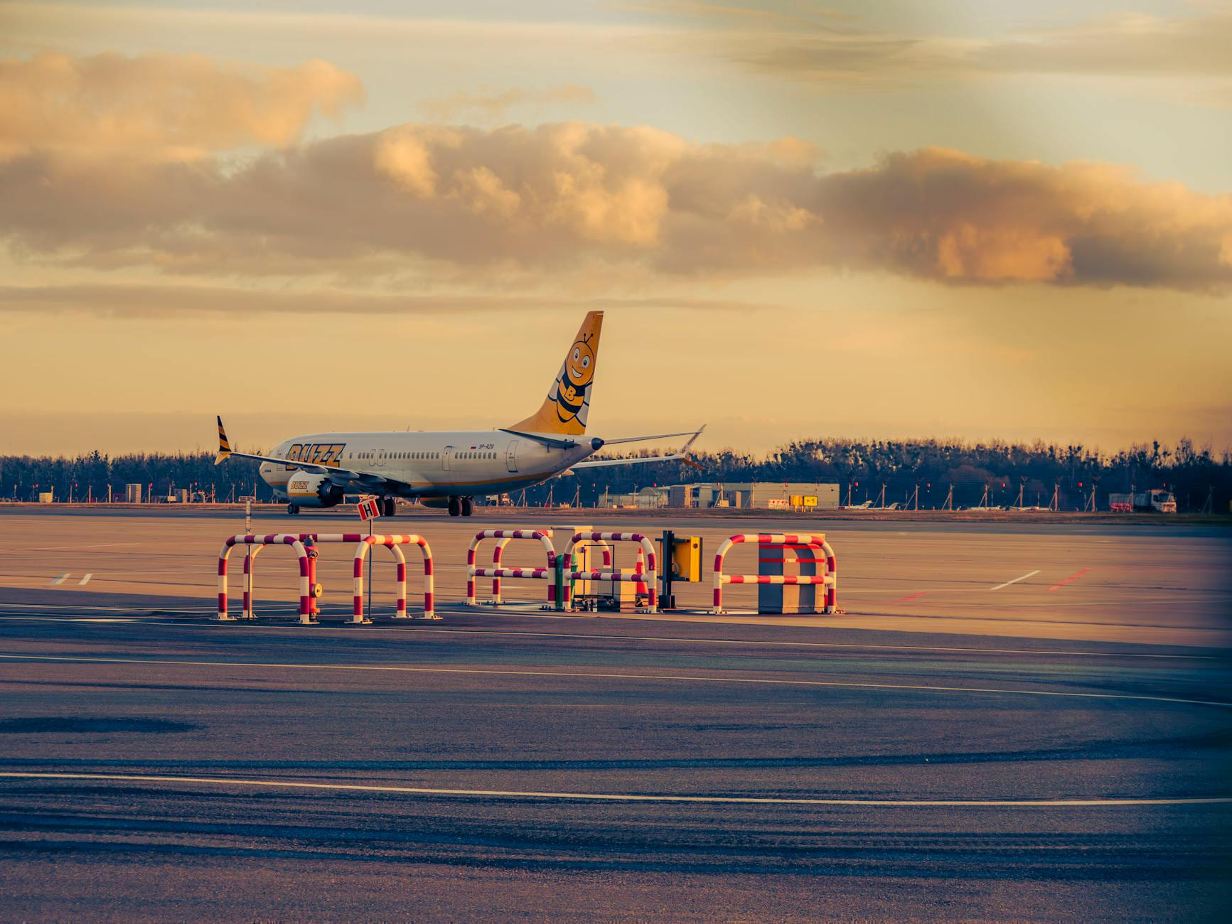 A colorful airplane on the runway at Wrocław Airport during sunset, showcasing vibrant skies and airport infrastructure. on Miles and Memories