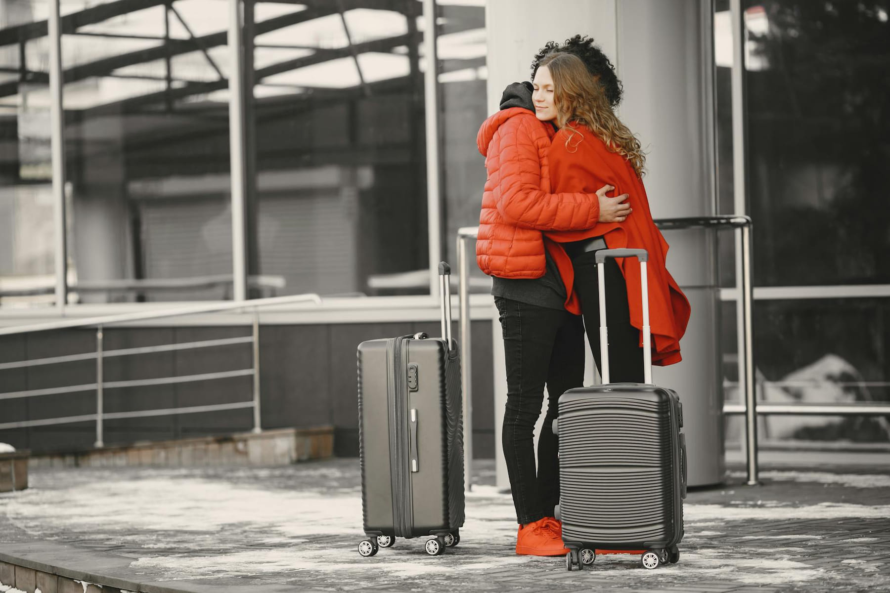 A heartfelt goodbye at the airport with two people hugging and luggage present. on Miles and Memories
